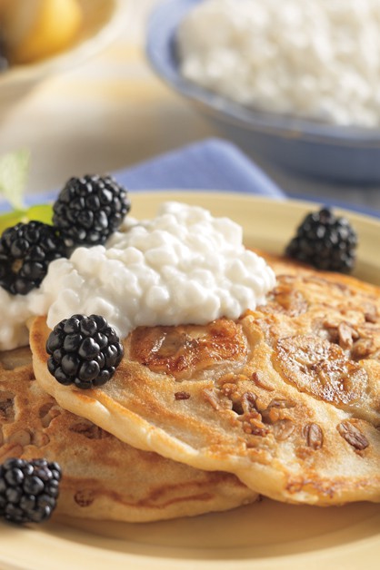 banana granola pancakes on plate with cottage cheese and blackberries on top
