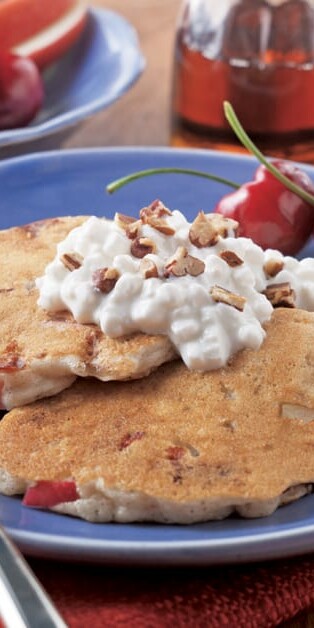 stack on cinnamon apple pancakes on a plate with cottage cheese