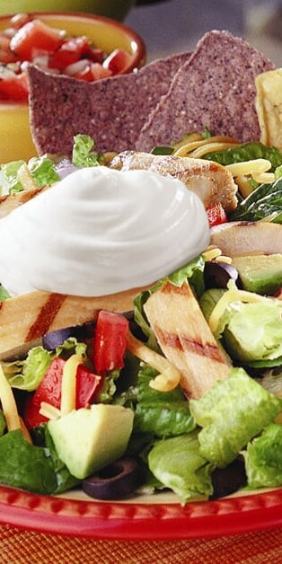 grilled chicken nacho salad on plate with chips 