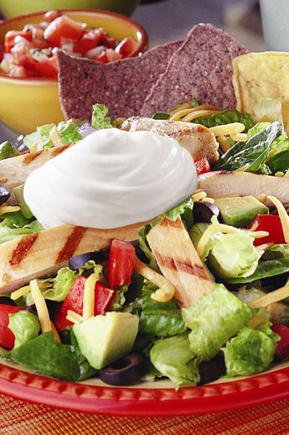 grilled chicken nacho salad on plate with chips