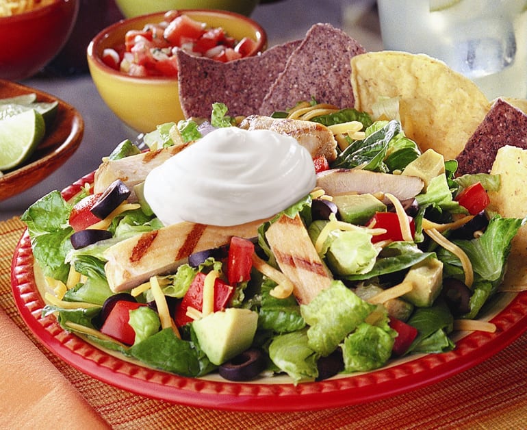 grilled chicken nacho salad on plate with chips