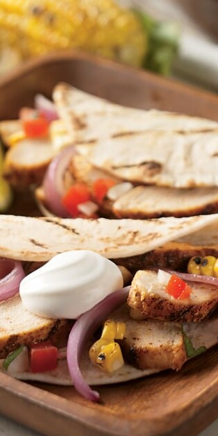Grilled chicken tacos with sour cream and vegetables