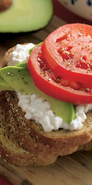Open Faced Hearty Wheat Sandwich with bread sliced, cottage cheese, avocado, and tomato