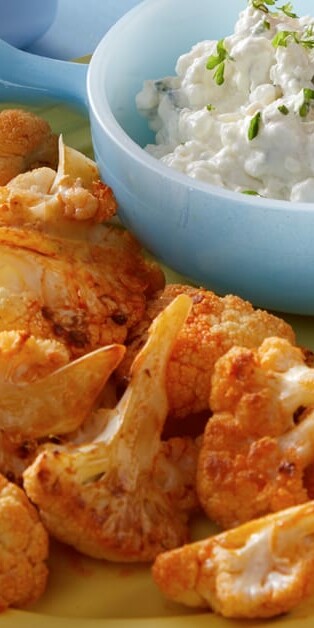 buffalo roasted cauliflower on plate with a side of cottage cheese