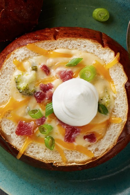 Sopa de cerveza con queso en un tazón de pan con crema agria en la parte superior