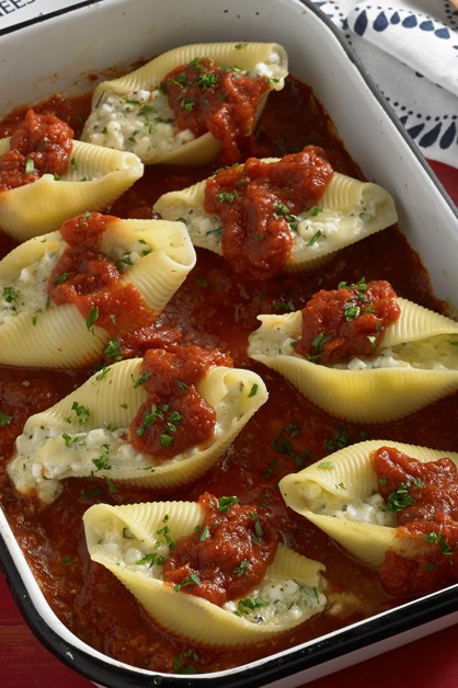 Three cheese stuffed shells in pan with red sauce